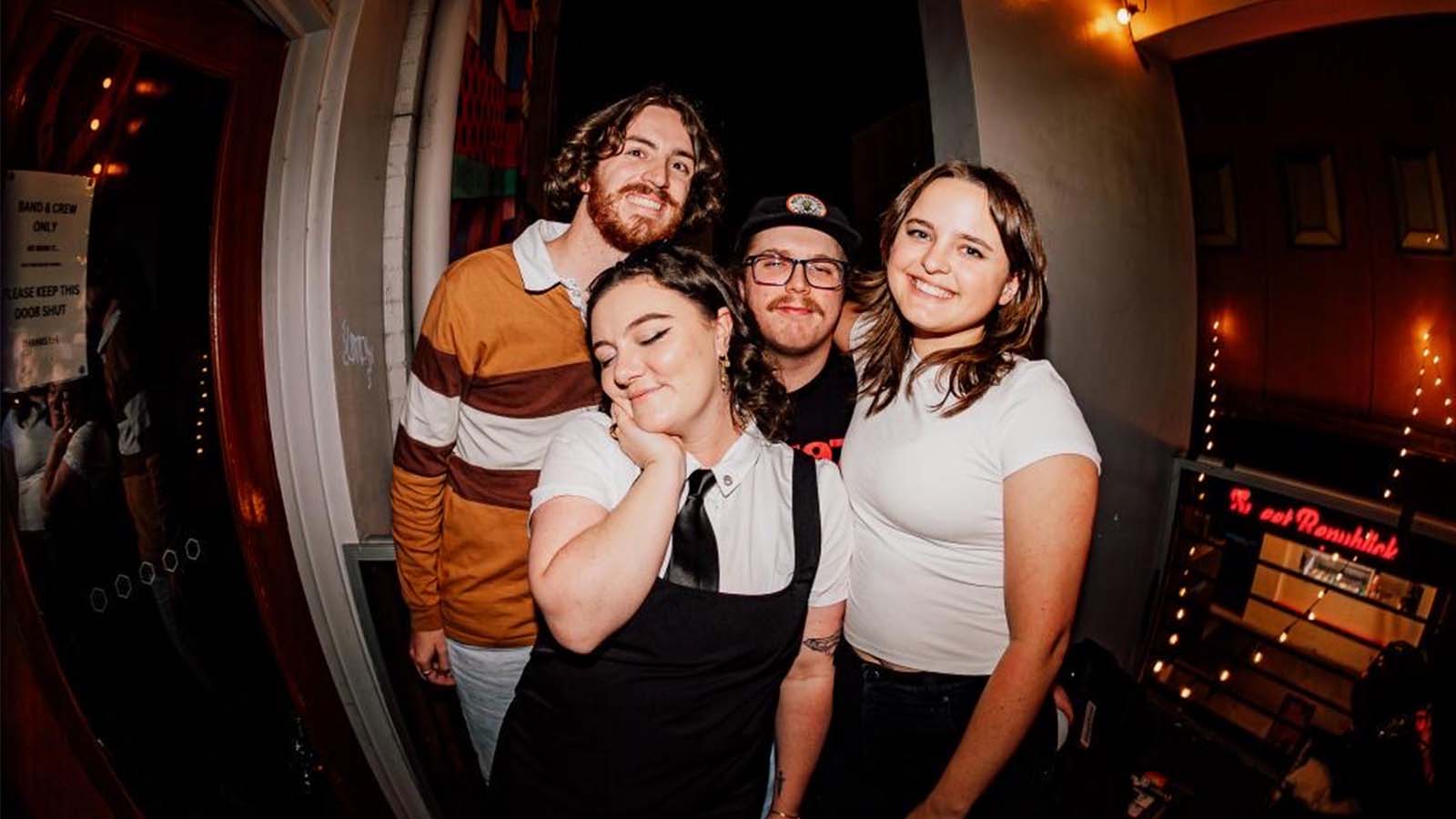 Two men and two women are standing on a balcony