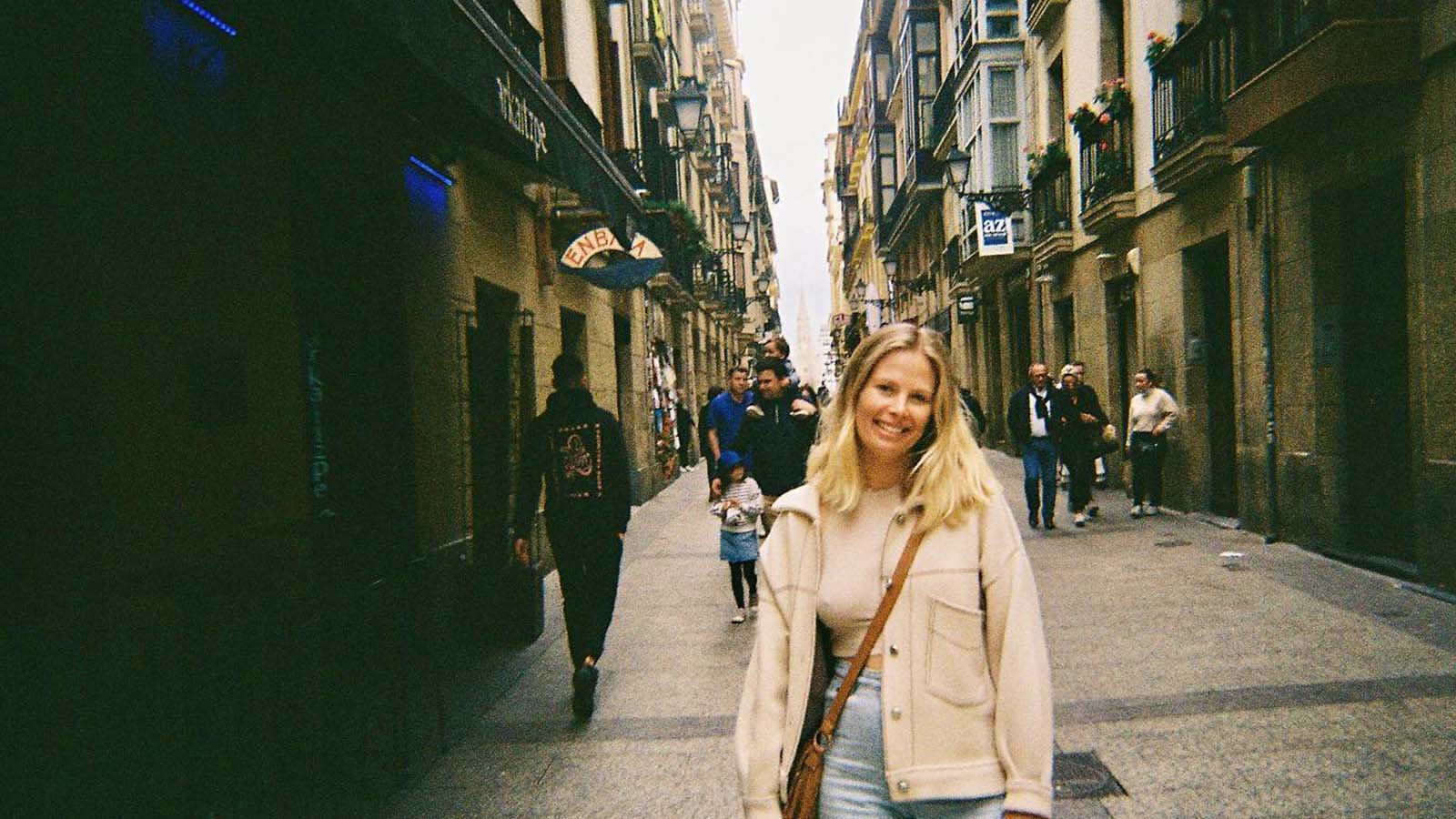 Student smiling in a cobblestone street in Spain