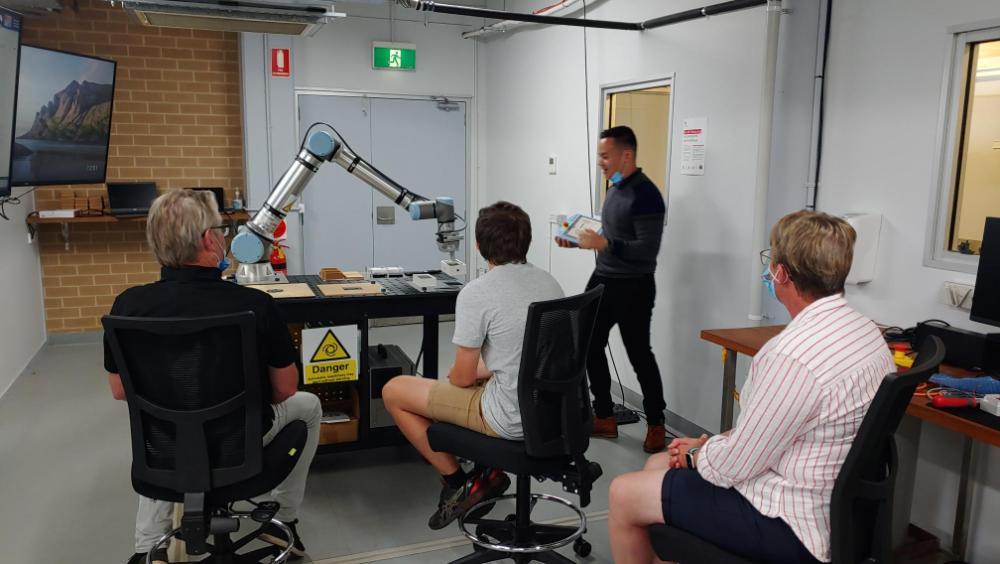 Image of engineers demonstrating cobot