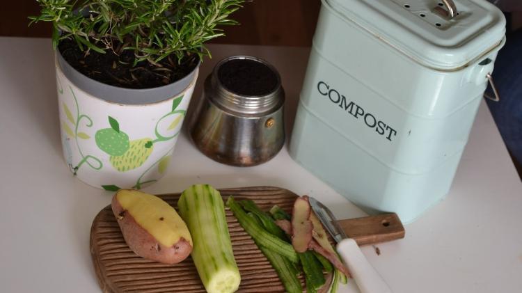 Food on cropping broad next to a tin with compost written on it