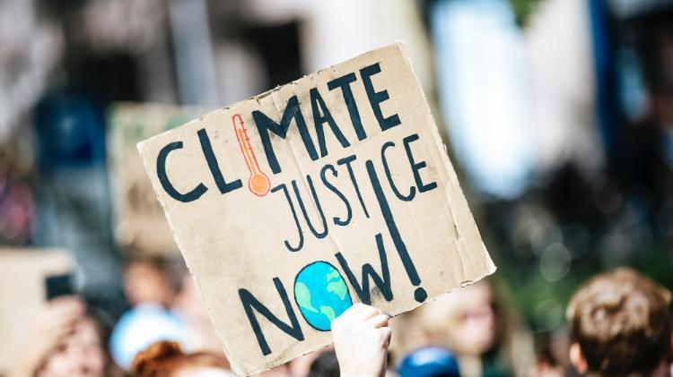 A protest sign with the words climate justice now