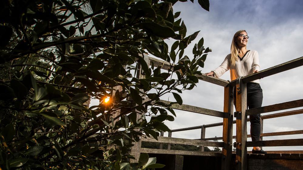 UOW Ecologist Associate Professor Kerrylee Rogers stands on a bridge overlooking water