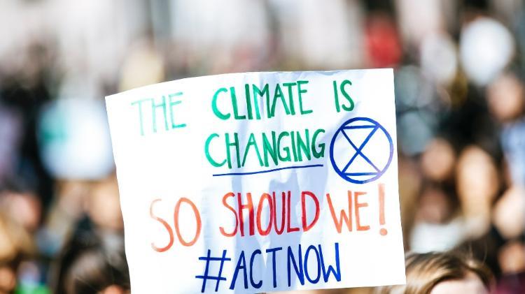 A protest sign with the words climate is changing. So should we. #actnow
