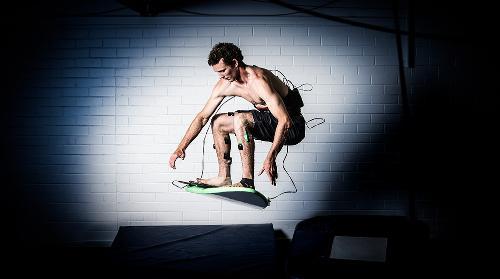 Surfer on a board with tracking equipment strapped to his leads and back