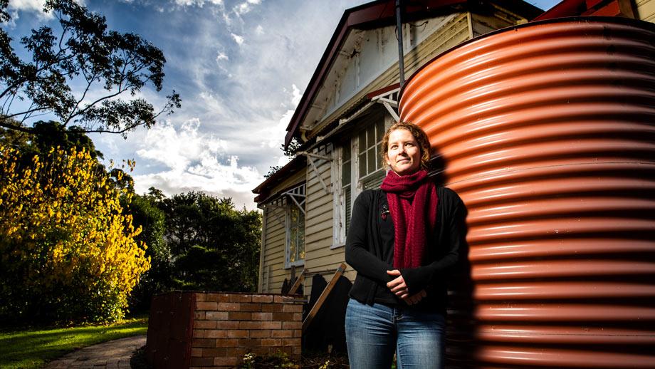 UOW's Carrie Wilkinson standing next to a water storage unit.