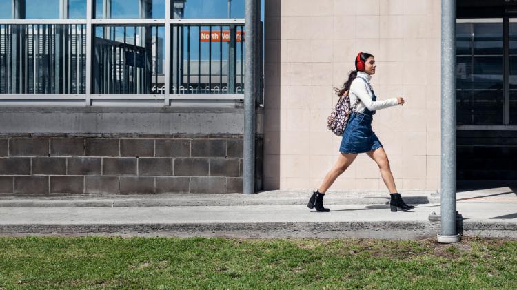 A student walking with purpose in front of North Wollongong train station