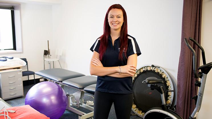 A UOW Exercise Science student stands in a gymnasium