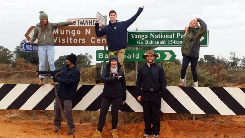 Groundswell earth science student society stand in front of Broken Hill road signsl trip
