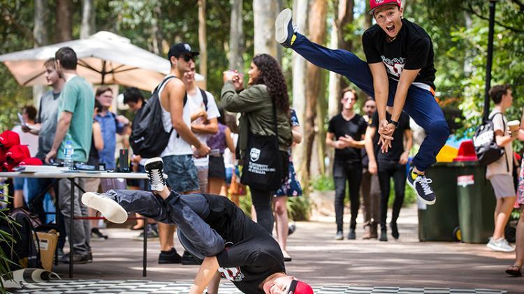 Two student members of the UOW Groove Central society show off their breakdancing
