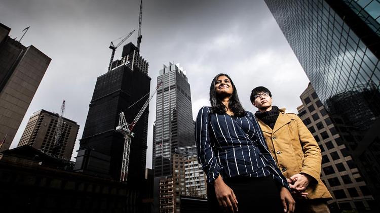 2 people standing on a city backdrop