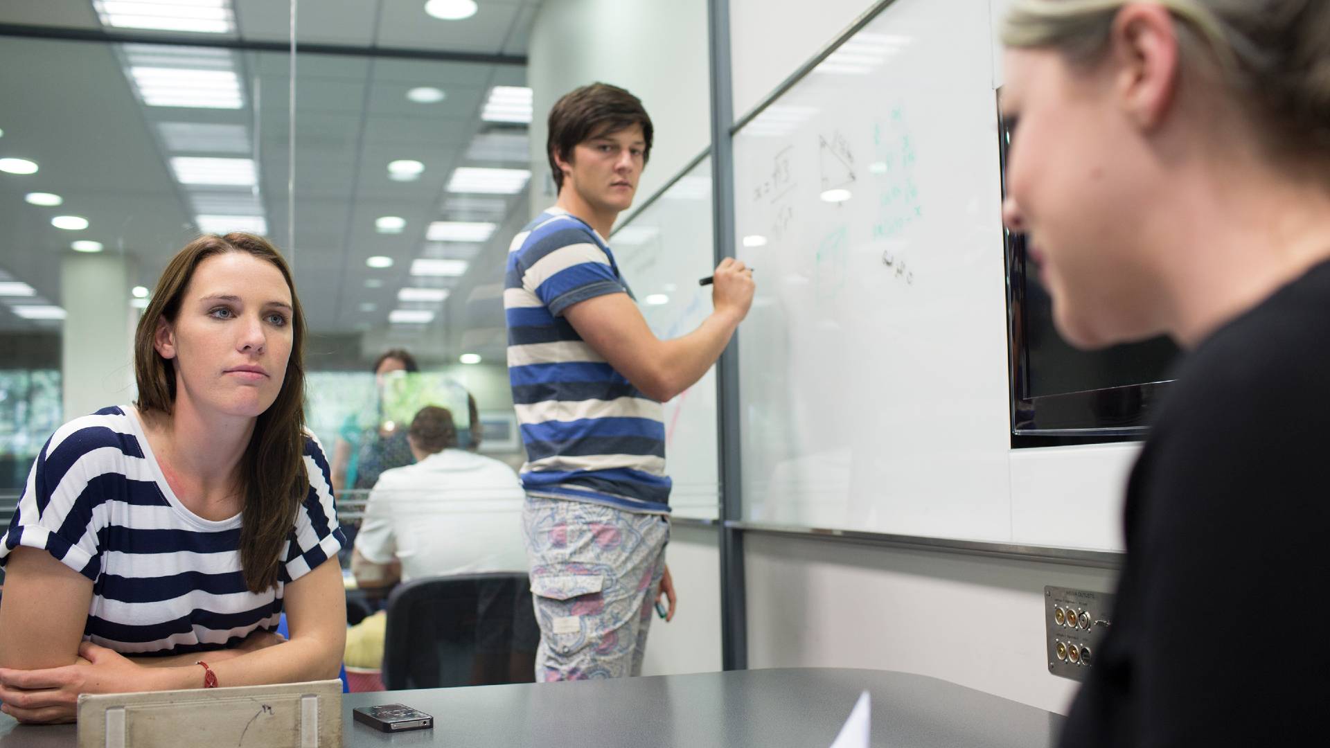 Students in study room writing on whiteboard