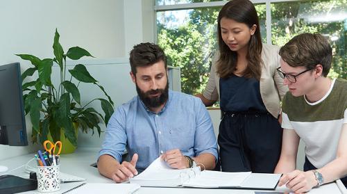 A UOW Business Intern looks at paperwork with manager