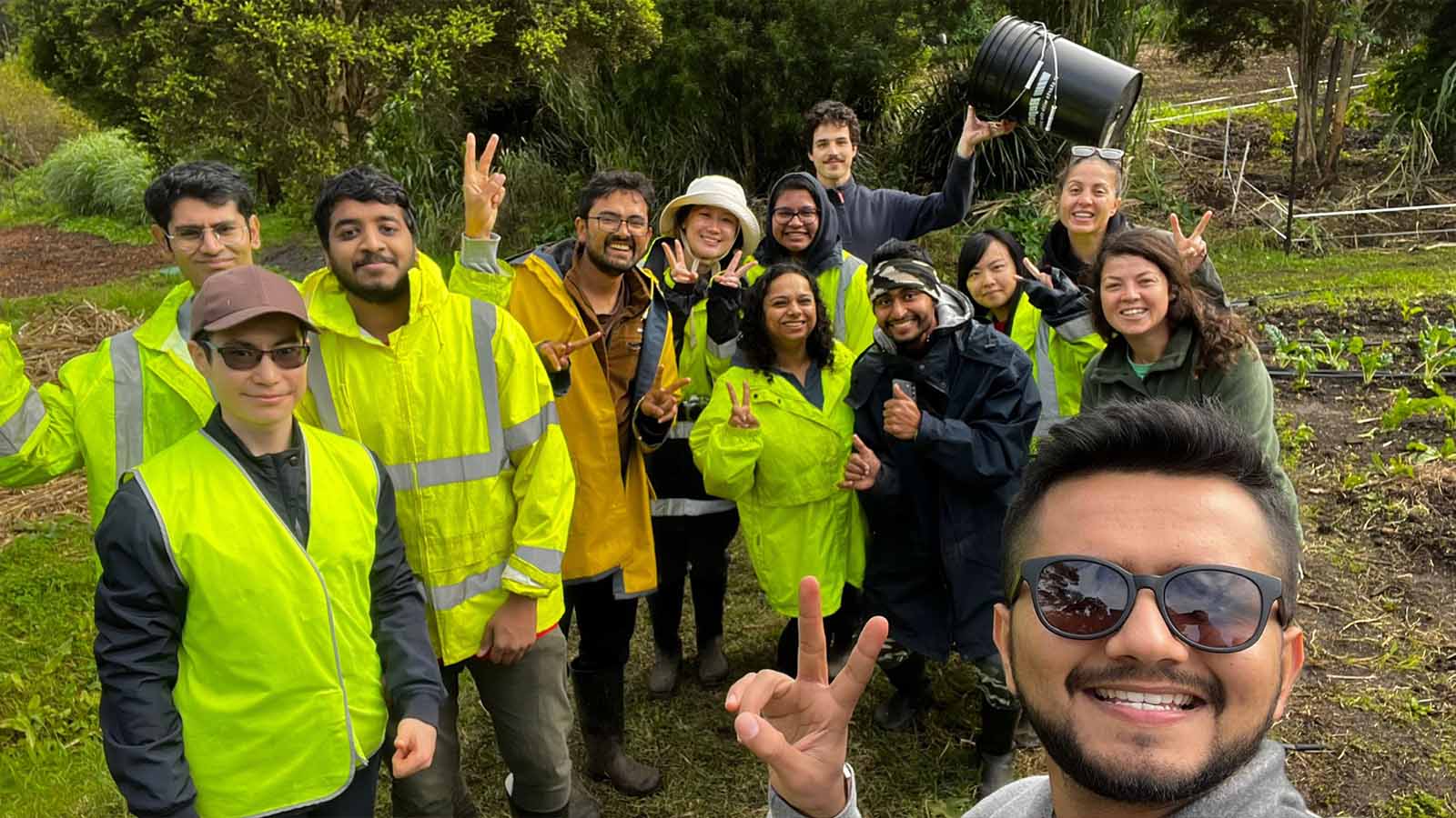 UOW student Vatsal stands with a group of other peoople planting trees