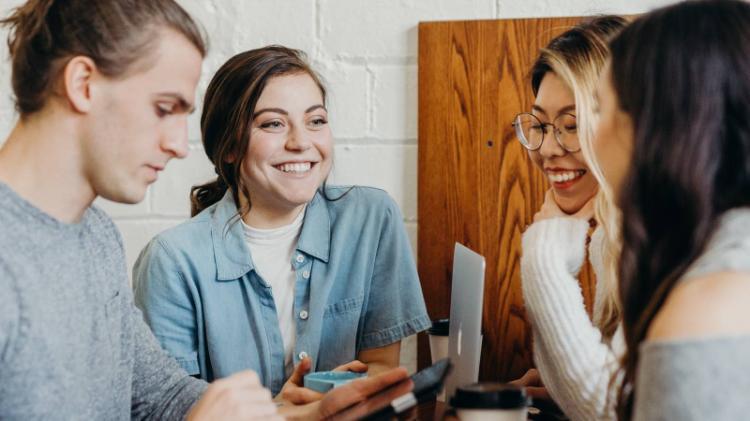 Group of students smiling around a table