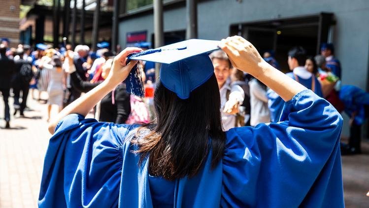 Image of the back of a student dressed in a graduation gown