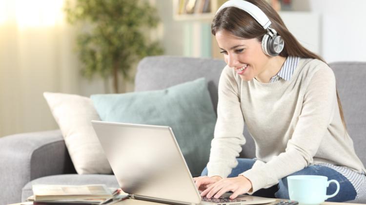 Student with headphones and laptop studying from home