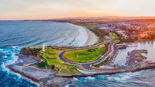 Aerial image of the Wollongong white house, which sits overlooking the ocean and Wollongong harbour during sunset.