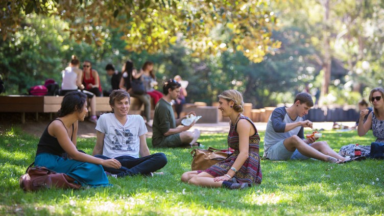 students sitting on duckpond lawn, UOW Campus