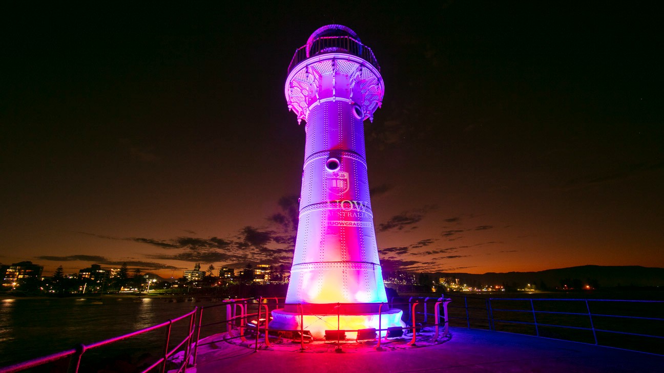 Wollongong lighthouse at night, with purple spotlights