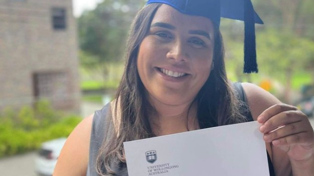Alex in her graduation hat, smiling with her testamur