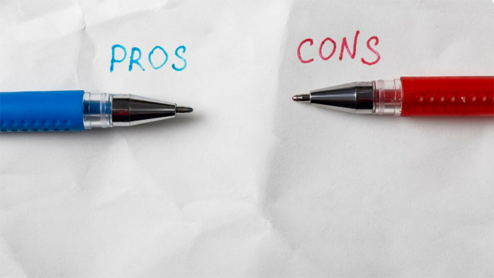 Two pens, blue and red, lie on crumpled white paper. The word 