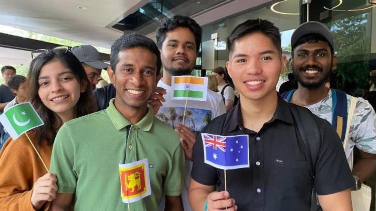 Students smiling and holding countries flags.
