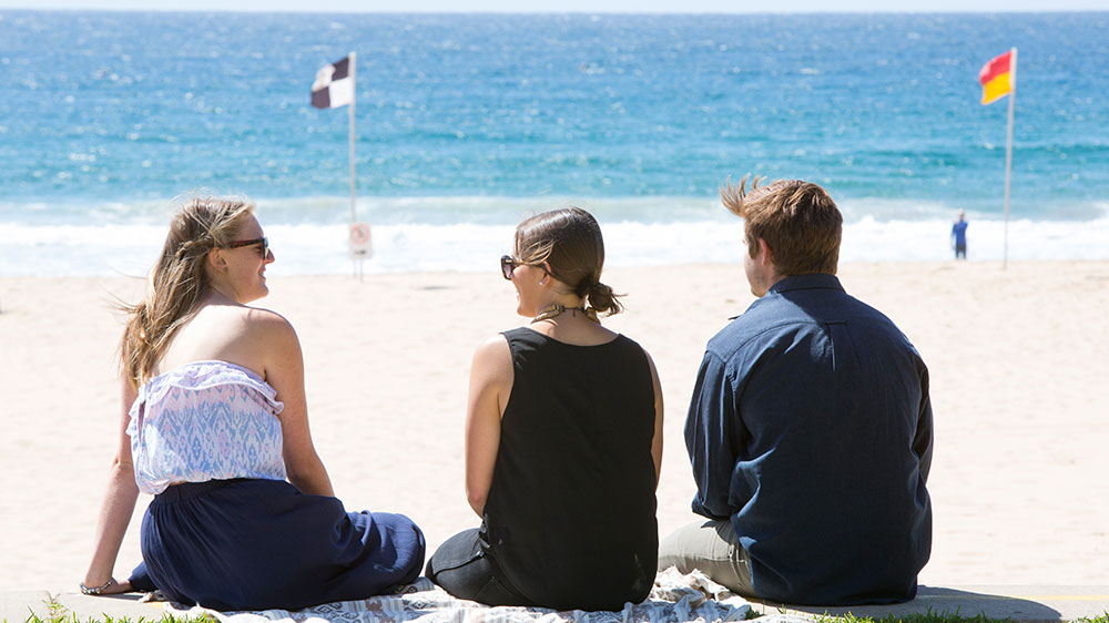 Students sitting at North Beach Wollongong