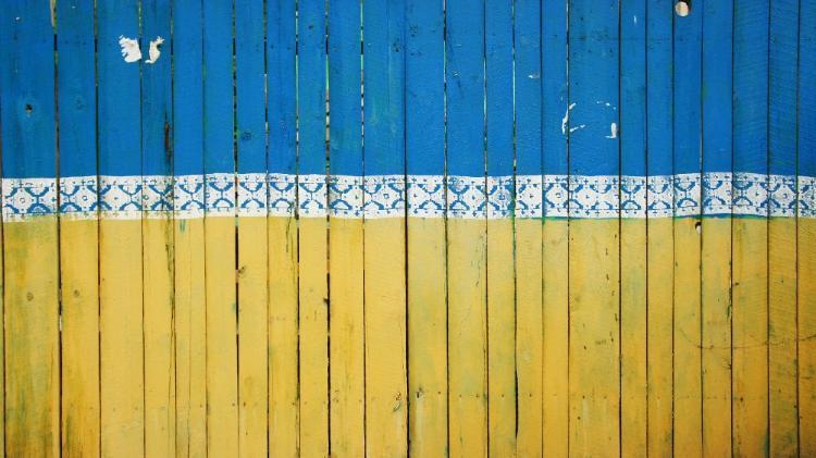 Fence painted in Ukraine's flag colours blue, white and yellow