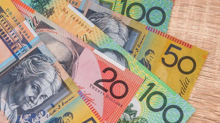 A variety of Australian banknotes in denominations of 20, 50, and 100 dollars arranged in a pile.