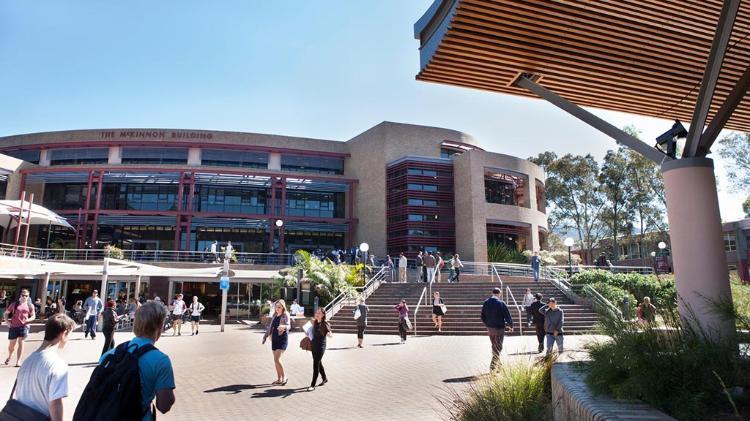 Front steps of McKinnon Building with student walking