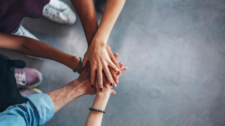 People's hands stacked together