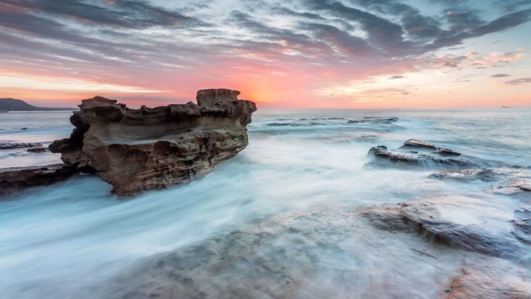 Rocks in ocean waters at dusk