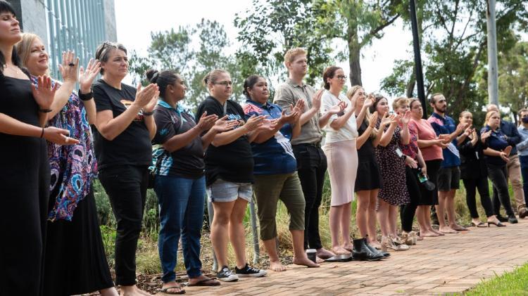 People standing in a line clapping