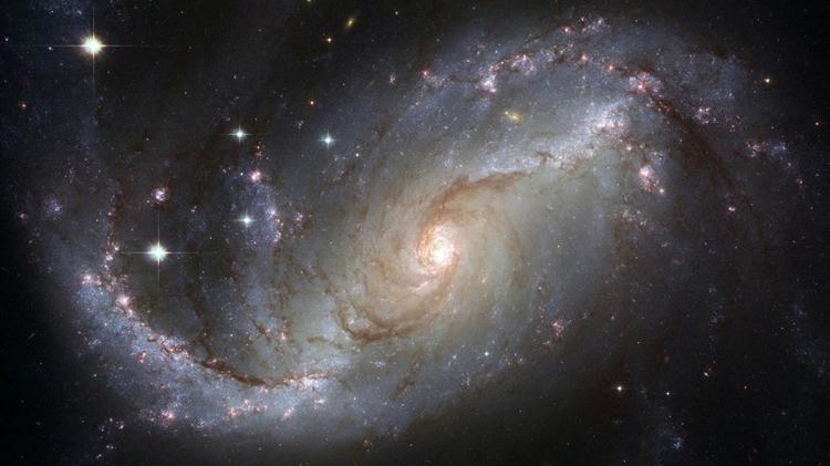 A stunning spiral galaxy illuminated by stars, showcasing vibrant colors and intricate structures of cosmic dust and gas.