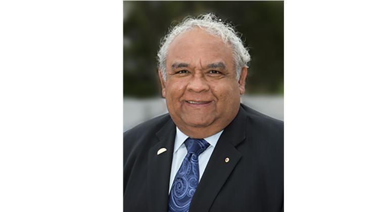 Professor Tom Calma wearing a suit and tie