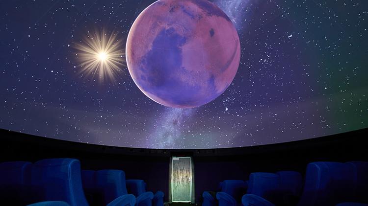 Inside the planetarium at UOW's Science Space. It shows cinema style seating with stars, moon and galaxy