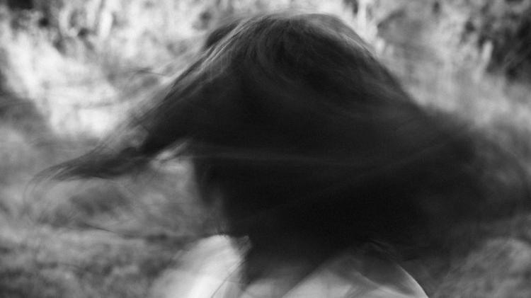 Black and white image: Back of person's head when turning as their hair moves.
