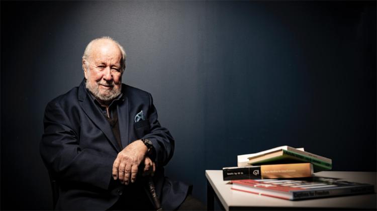 Stephen Hill sits near a pile of books.