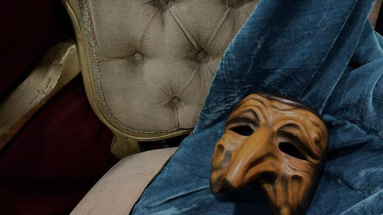Gold mask on chair with a blue cloth.