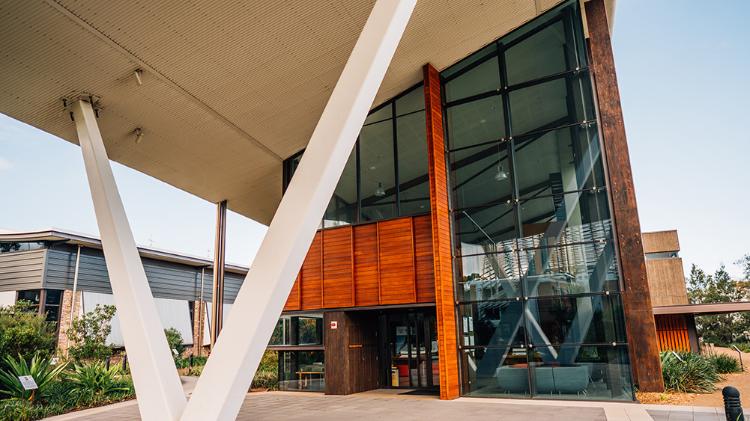 Glass entrance with the SBRC building. A large winter V-shaped pilar holds the outside cover.