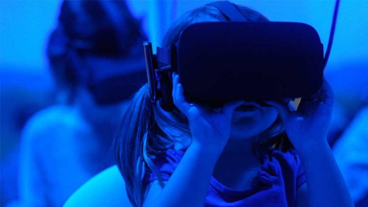 Child wearing simulation goggles in a blue lighted room