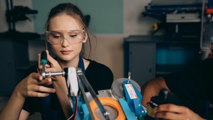 Woman Engineer wearing safety glasses as working with a device