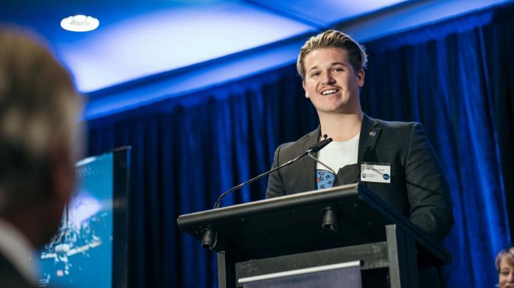 AIME alumni Joshua Scott addresses the awards ceremony