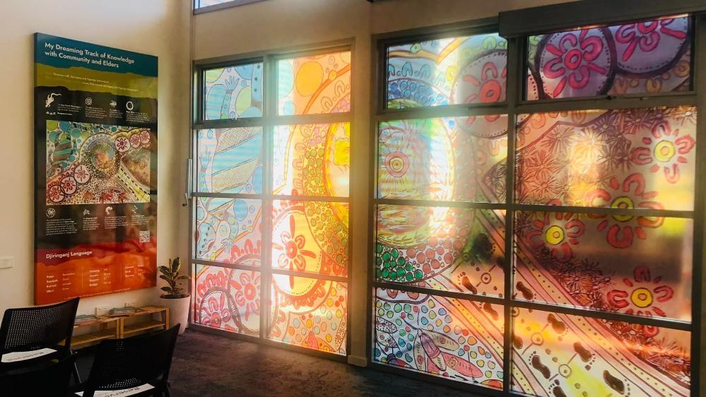 The new Djiringanj artwork, painted on the windows at UOW Bega Valley, is reflected in the sunlight. Photo: Supplied