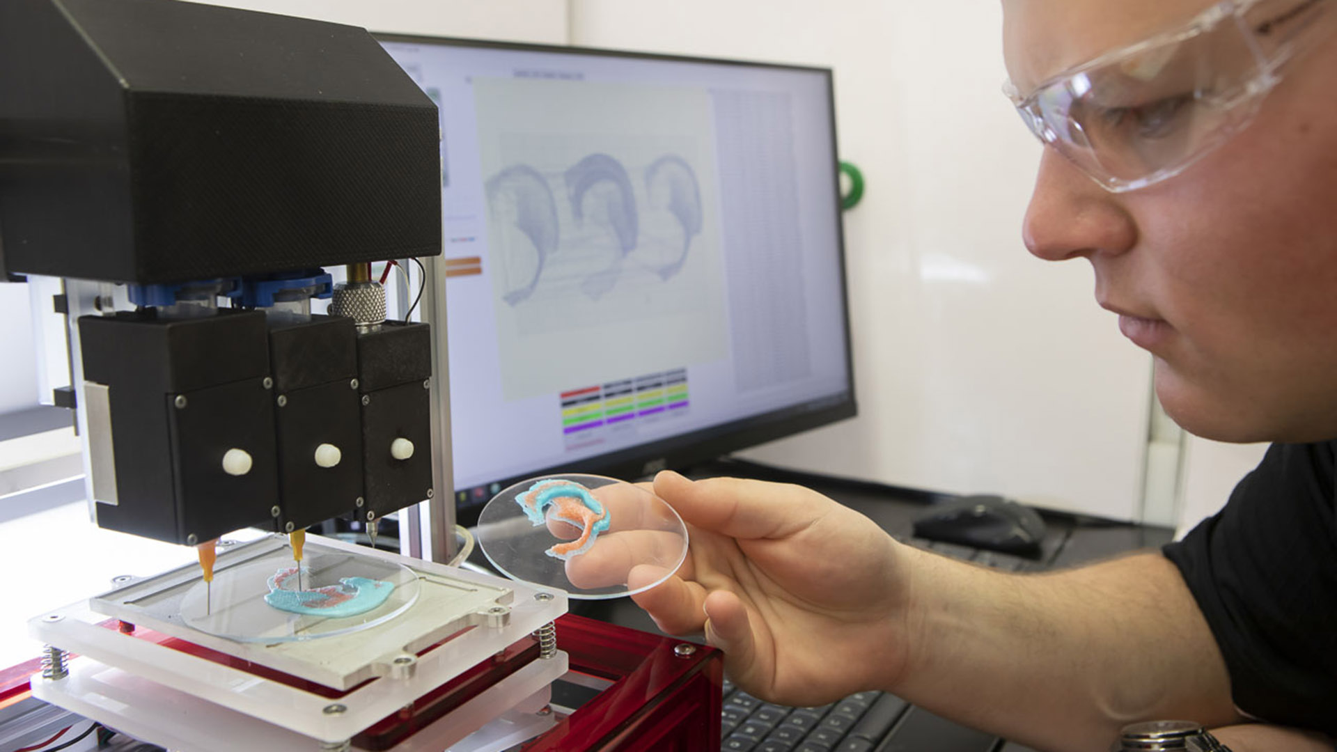 A researcher with a 3D printed ear at the Australian National Fabrication Facility