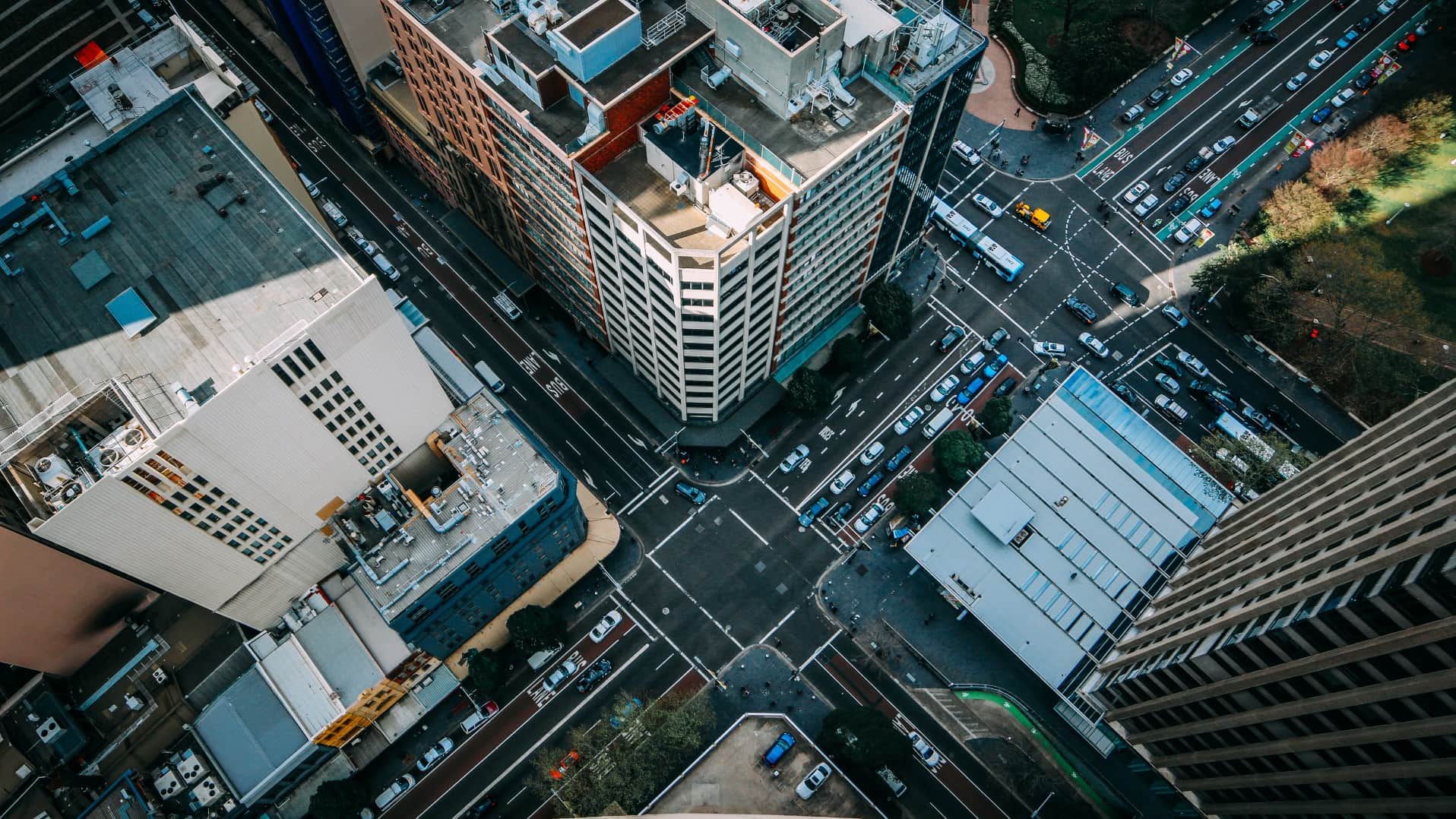 An aerial view of Sydney city, looking down on high-rise rooftops and intersections. Photo: Unsplash/Alexander Pidgeon
