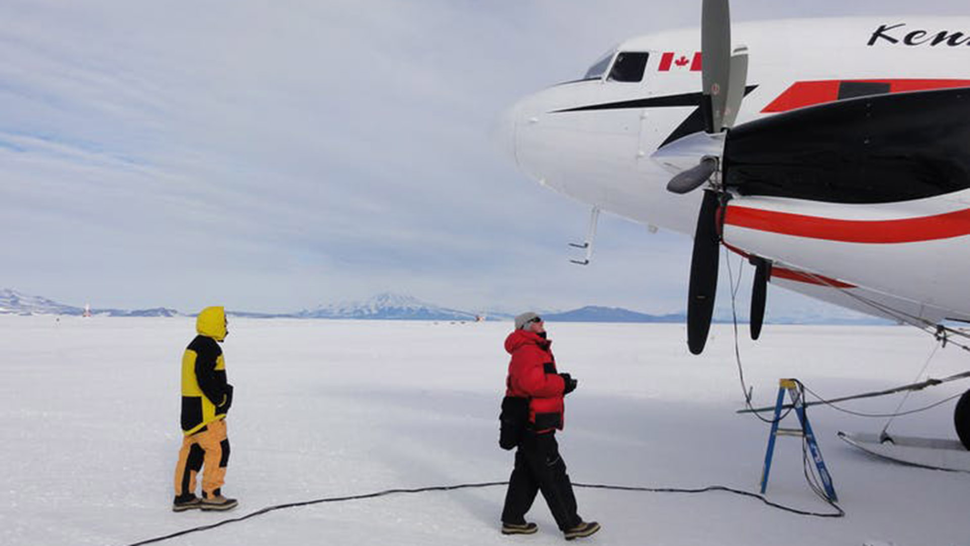 Researchers approach a plan on an airstrip in Antarctica. Photo: Dana Bergstrom
