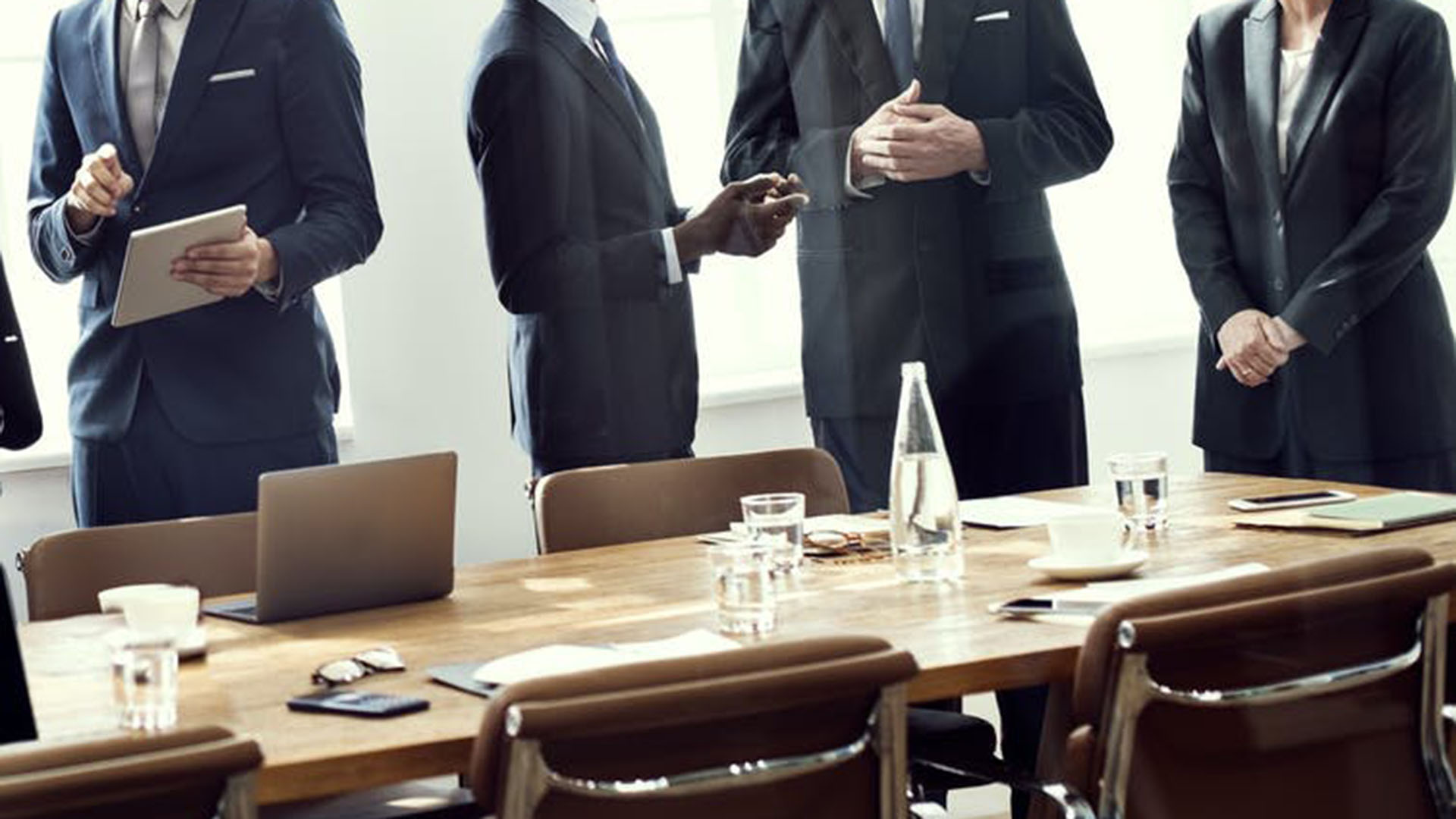 Generic image of men in suits at a meeting table
