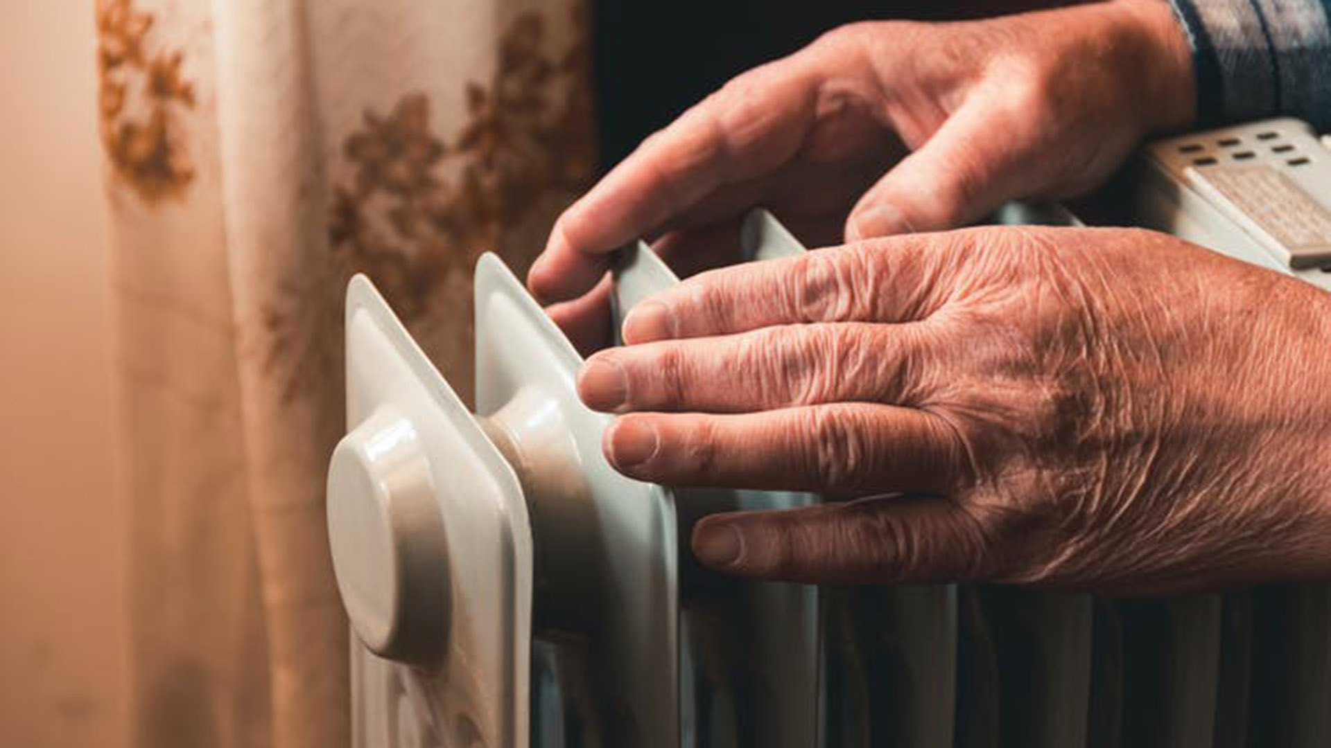 Generic image of person warming hands near heater. Shutterstock image