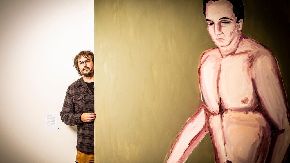 Creative arts graduate Damien Martin with his artwork in the show Zenith. Photo: Paul Jones